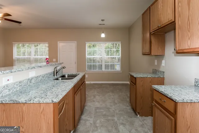 a kitchen with granite countertop sink stove and cabinets