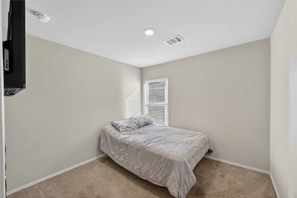 a bedroom with a bed and flat screen tv