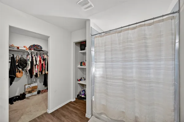 a view of walk in closet with clothes and shoes