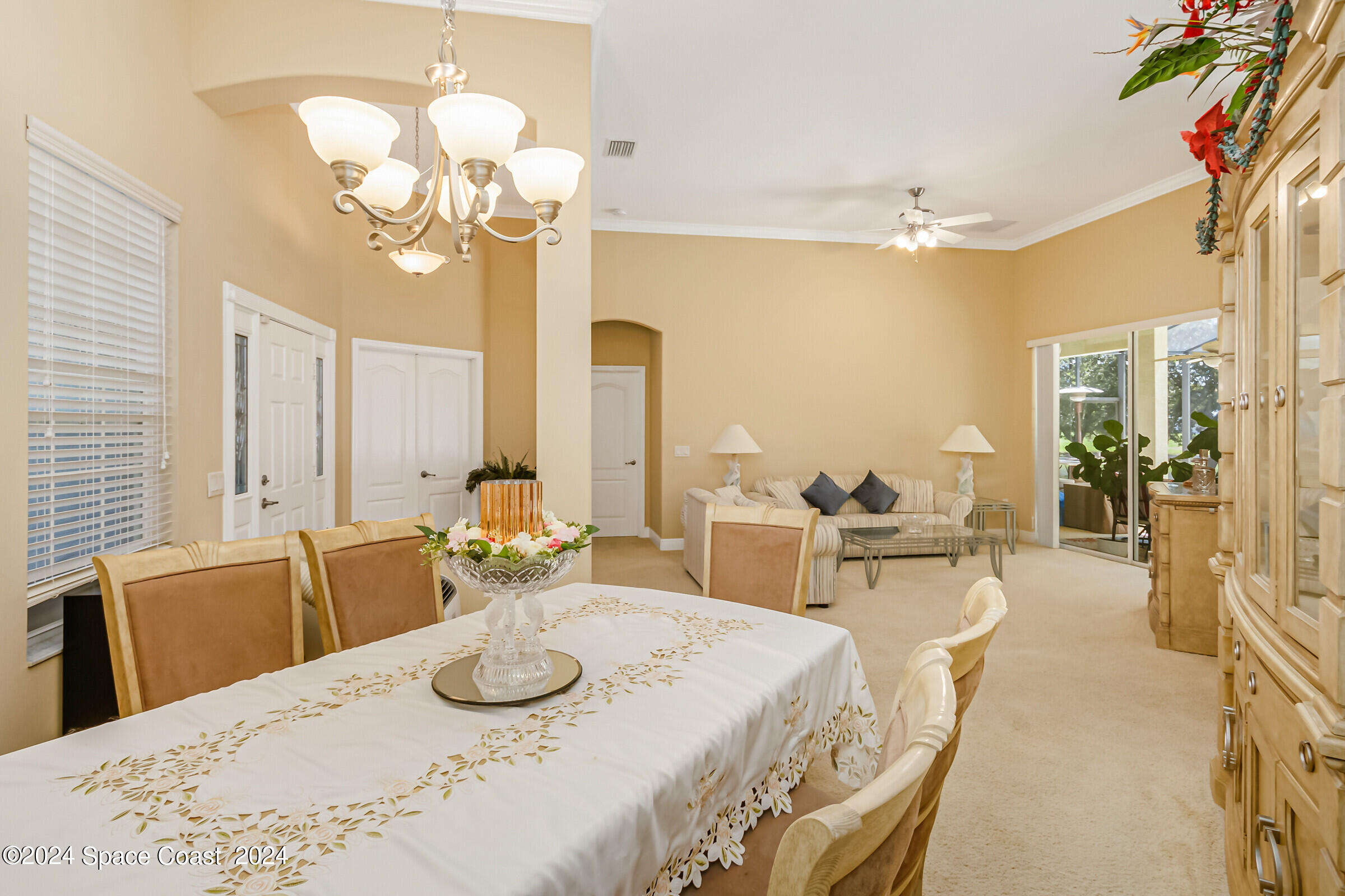 5972 Goleta Circle Melbourne, FL 32940 - Photo 18 of 56 a view of a dining room with furniture a chandelier and large windows