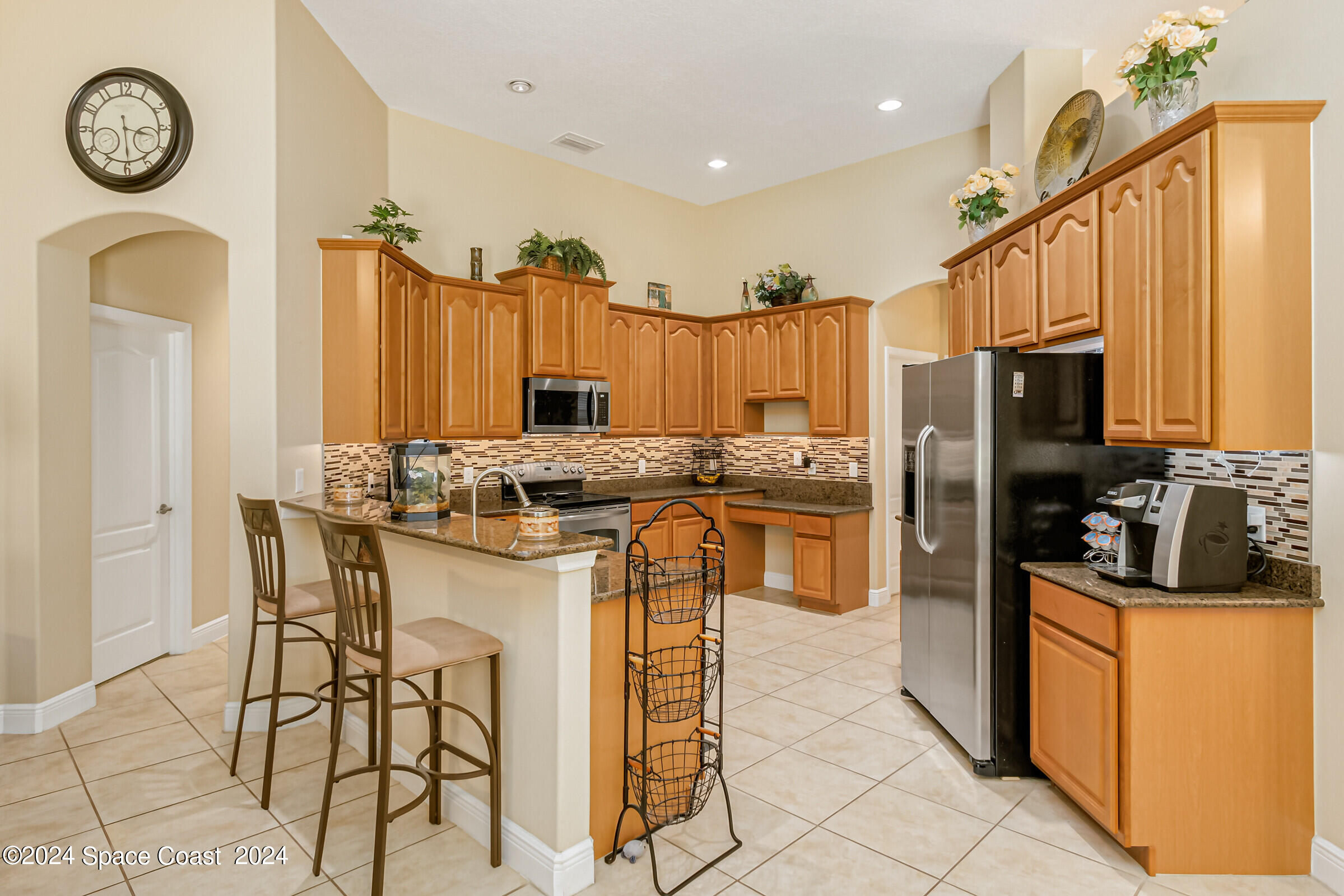 5972 Goleta Circle Melbourne, FL 32940 - Photo 22 of 56 a kitchen with stainless steel appliances granite countertop a stove a refrigerator a oven a sink with island chairs and cabinets