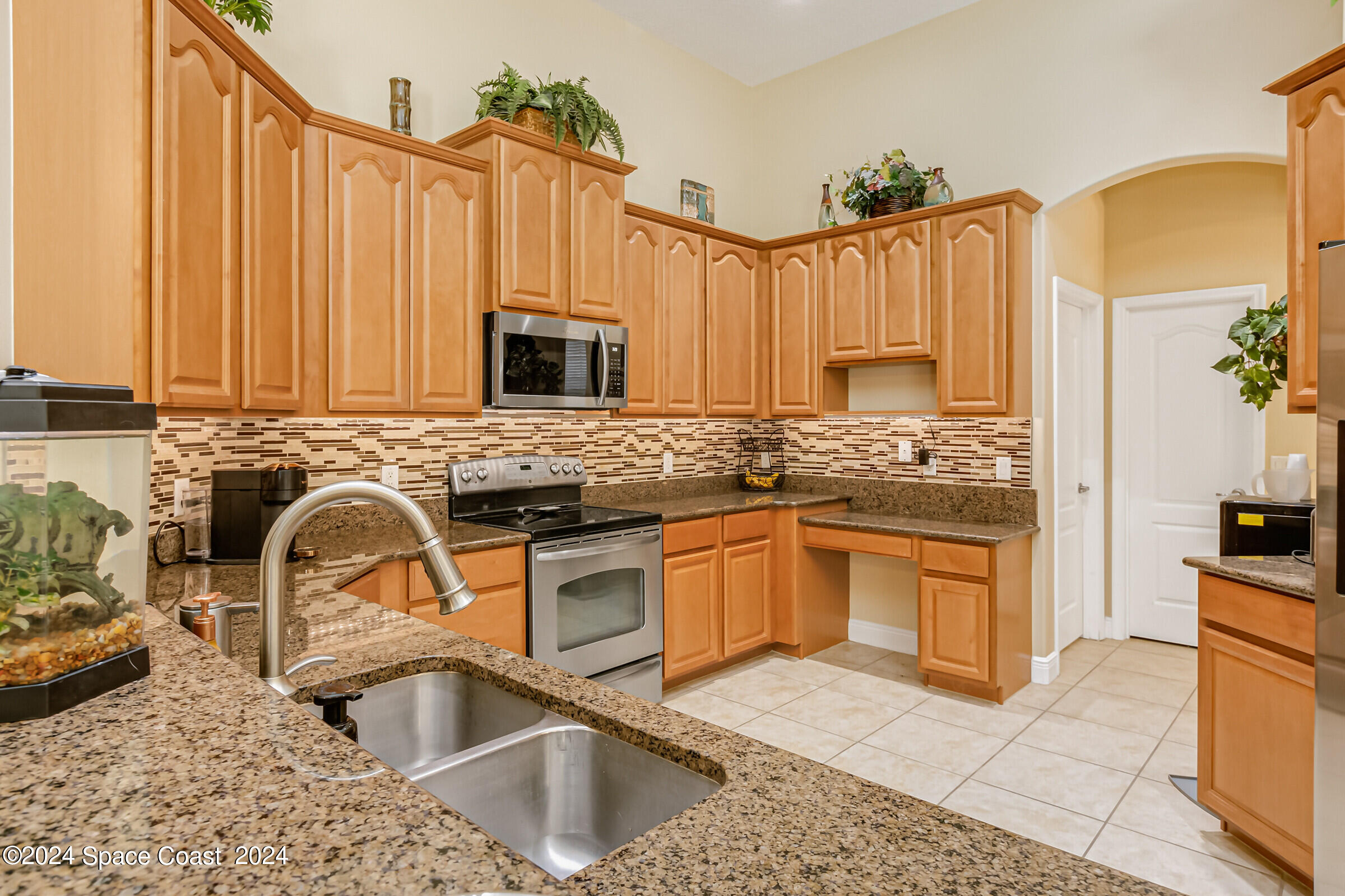 5972 Goleta Circle Melbourne, FL 32940 - Photo 23 of 56 a kitchen with stainless steel appliances granite countertop a sink stove and refrigerator