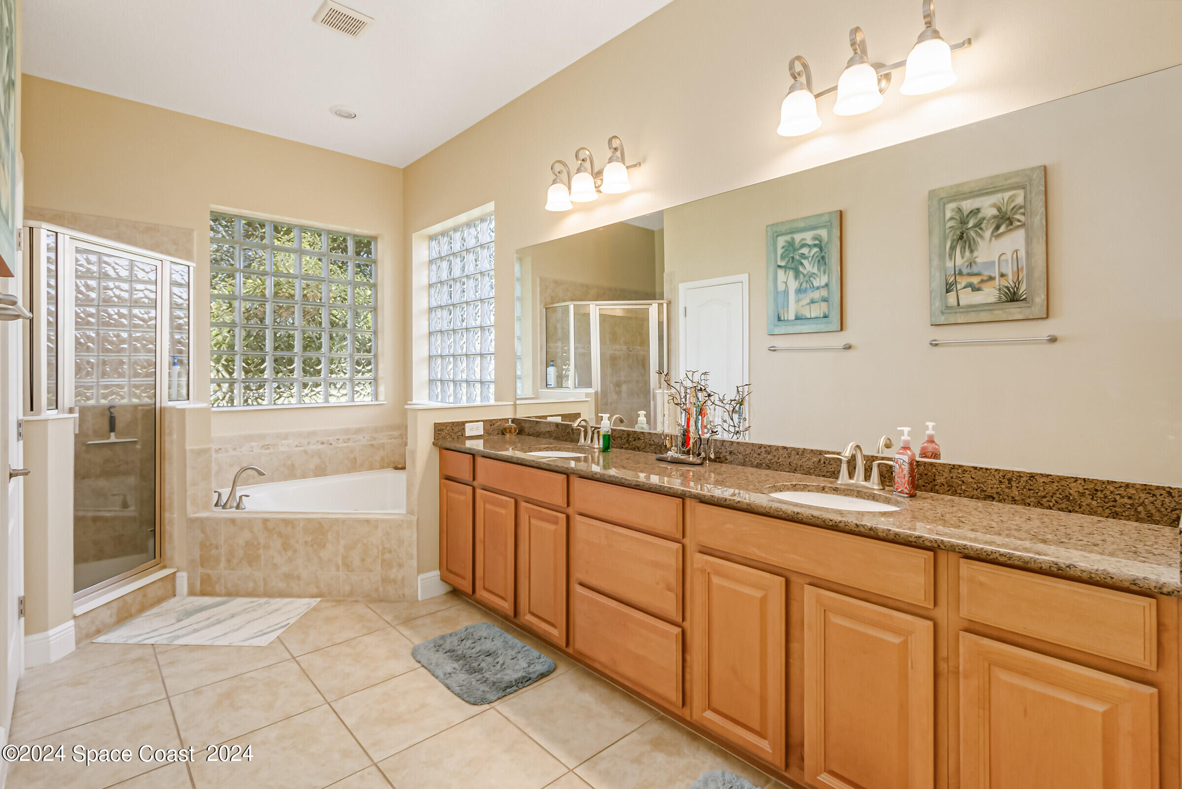 5972 Goleta Circle Melbourne, FL 32940 - Photo 37 of 56 a spacious bathroom with a granite countertop sink a toilet a large mirror and shower