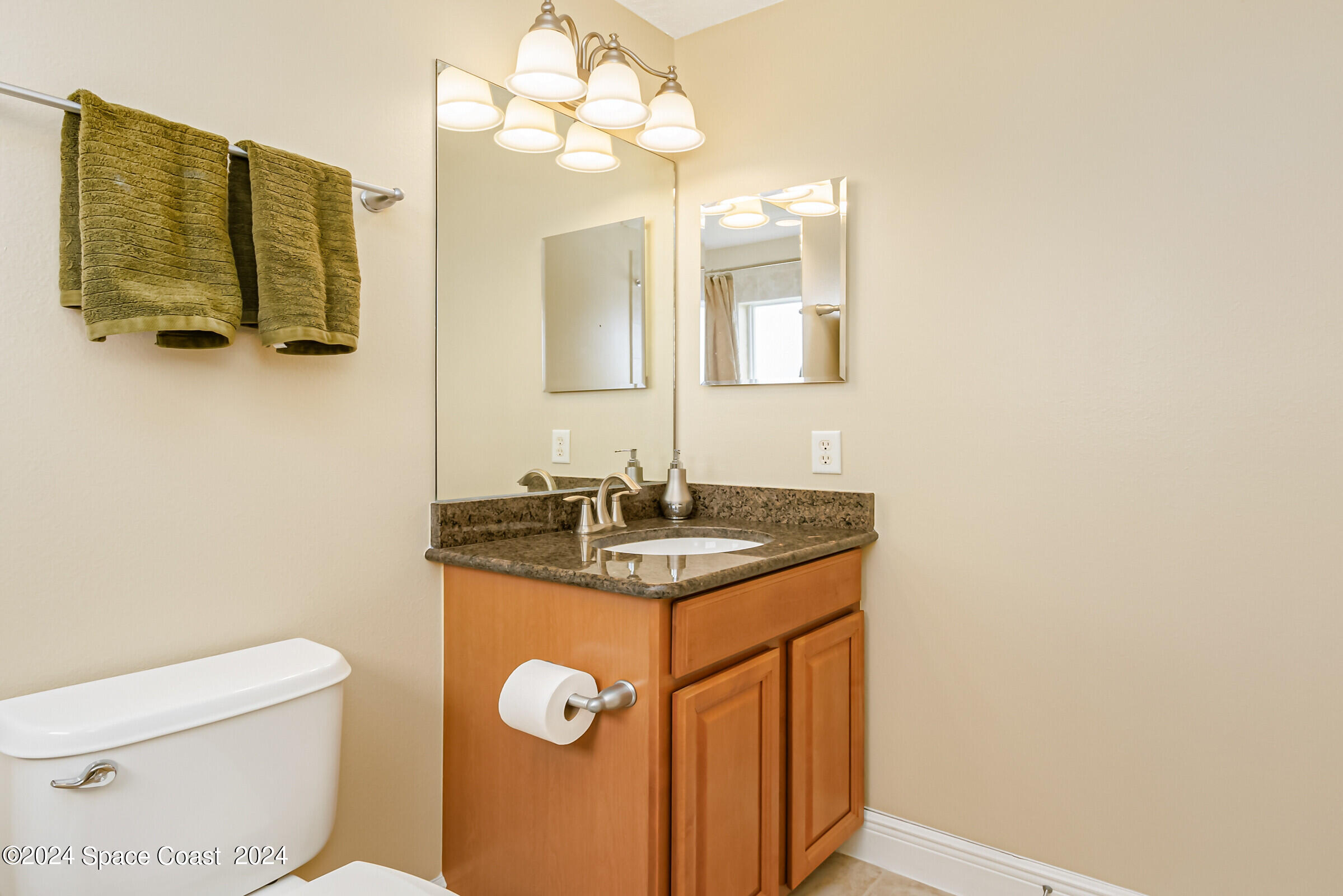 5972 Goleta Circle Melbourne, FL 32940 - Photo 50 of 56 a bathroom with a granite countertop toilet sink and mirror