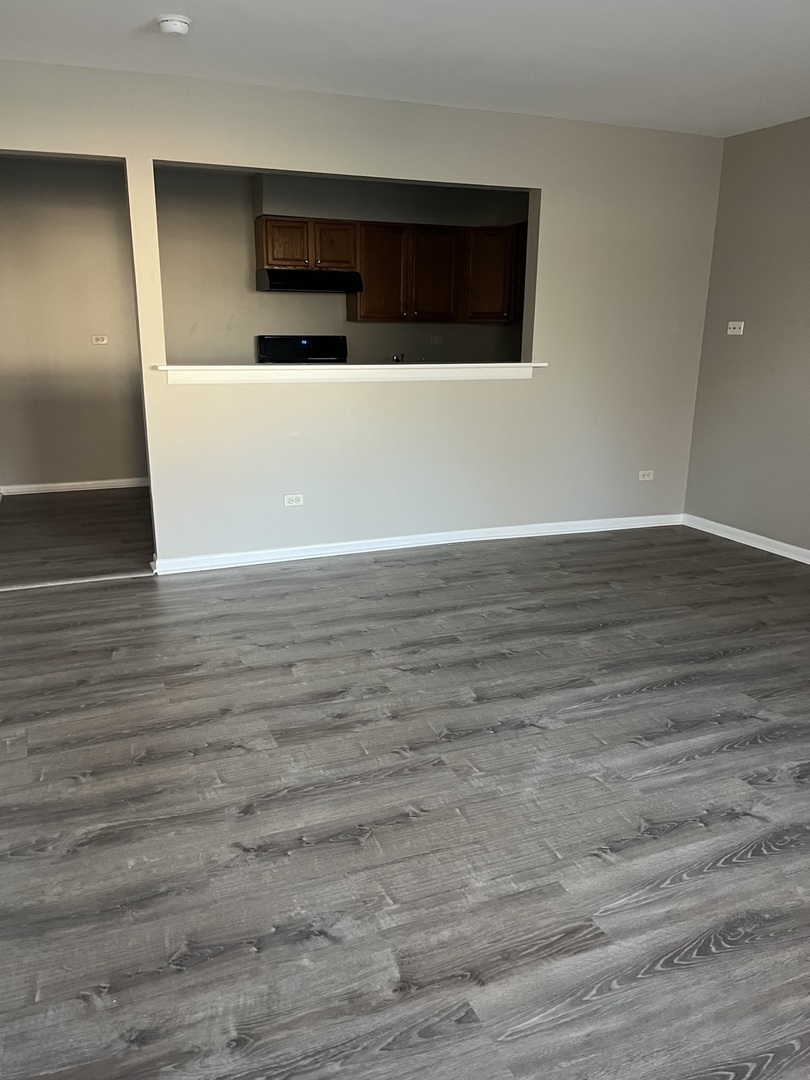 8817 South Roberts Road, Unit 5 Hickory Hills, IL 60457 - Photo 2 of 6 a view of an empty room with wooden floor and staircase