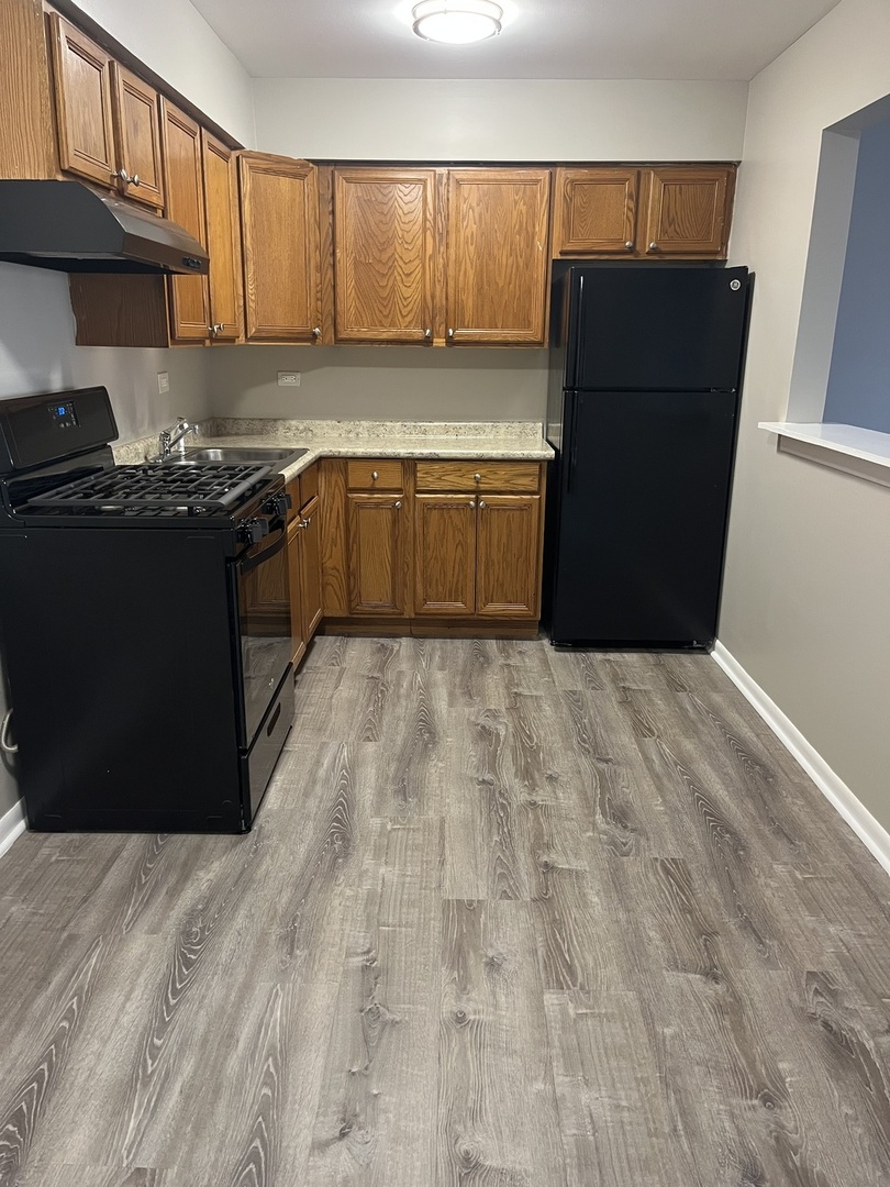 8817 South Roberts Road, Unit 5 Hickory Hills, IL 60457 - Photo 4 of 6 a kitchen with a refrigerator and a stove