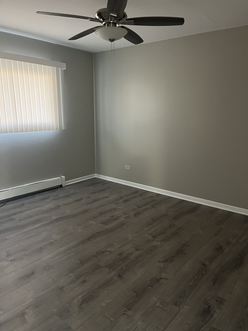 8817 South Roberts Road, Unit 5 Hickory Hills, IL 60457 - Photo 5 of 6 an empty room with wooden floor closet and windows