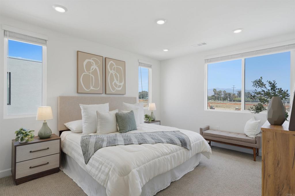 2402 Cascalote Loop San Diego, CA 92154 - Photo 19 of 35 a spacious bedroom with a bed and a couch