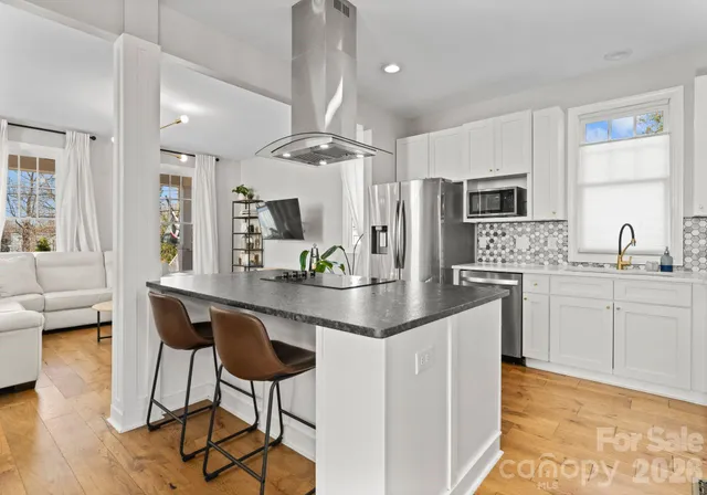 a kitchen with stainless steel appliances kitchen island granite countertop a sink and cabinets