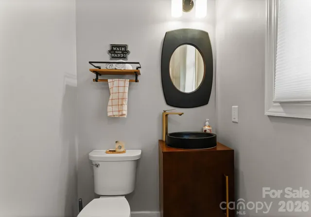a bathroom with a toilet a sink and a mirror
