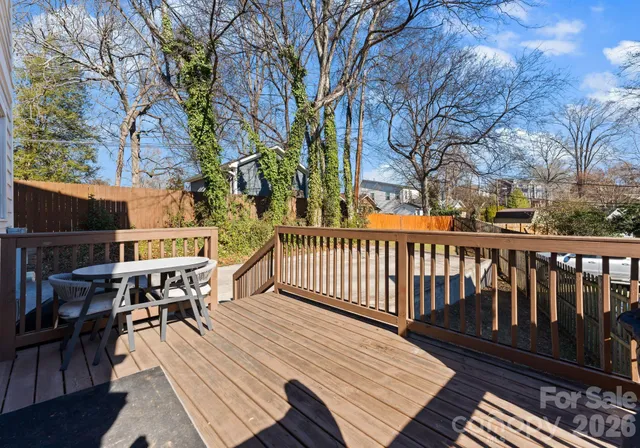 a balcony with wooden floor table and chairs