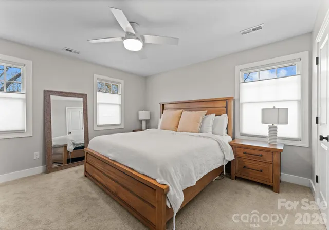 a bed sitting in a bedroom next to a window