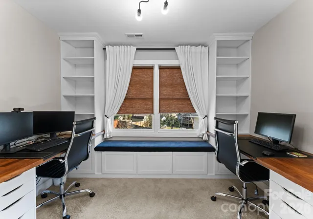 a view of a workspace with furniture and a window