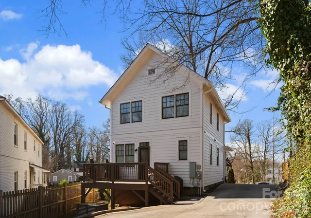 a view of a white house with a yard