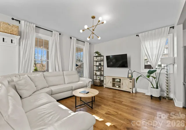 a living room with furniture a flat screen tv and a window