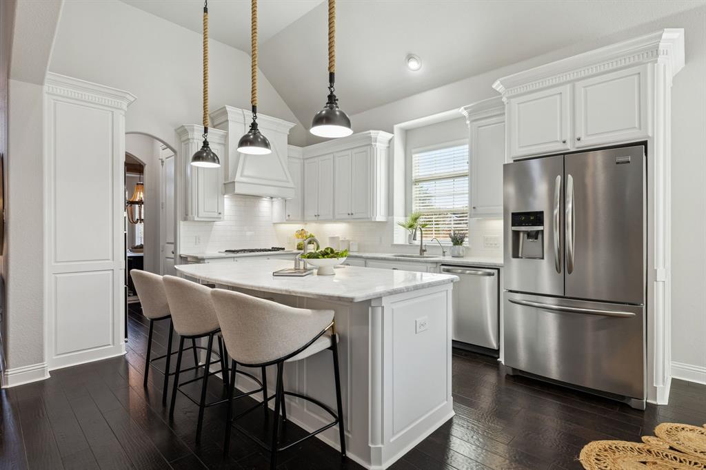 2816 Mona Vale Road Trophy Club, TX 76262 - Photo 11 of 40 a kitchen with stainless steel appliances granite countertop a refrigerator a sink dishwasher a kitchen island with wooden floor and chairs