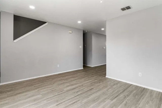 a view of an empty room with wooden floor