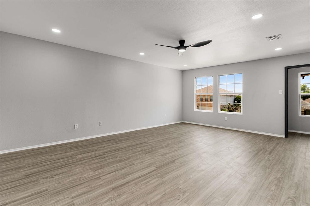 4529 Martingale View Lane Fort Worth, TX 76244 - Photo 18 of 38 an empty room with wooden floor ceiling fan and windows