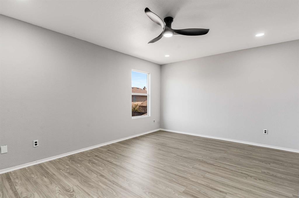 4529 Martingale View Lane Fort Worth, TX 76244 - Photo 20 of 38 a view of an empty room with wooden floor and a ceiling fan