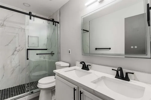 a bathroom with a sink toilet a mirror and shower