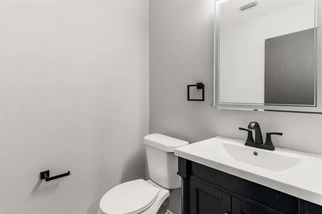 a bathroom with a toilet a sink and mirror