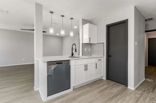 a kitchen with a sink cabinets and wooden floor