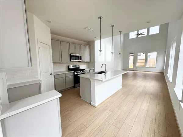 a large kitchen with a wooden floor and a large window