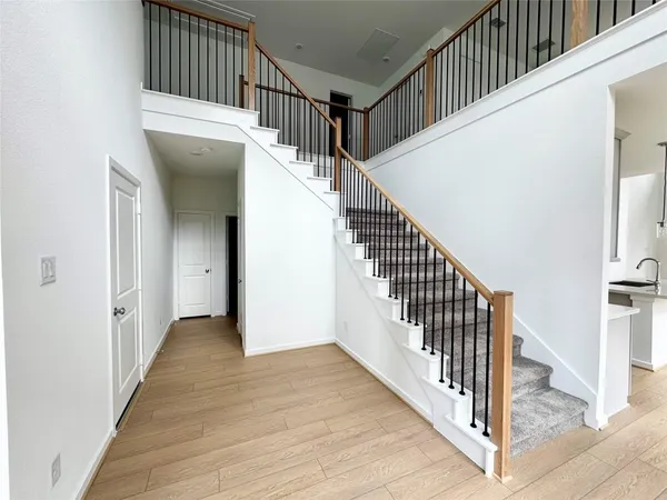 a view of a hallway with wooden floor and entryway