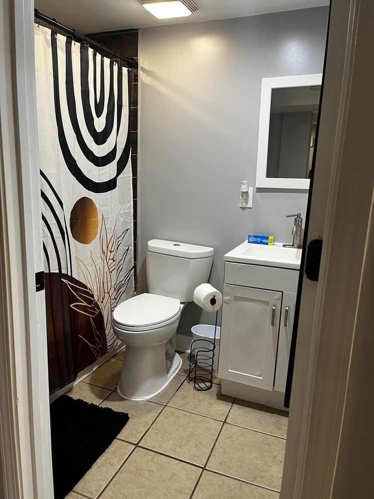 447 West 81st Street, Unit G Chicago, IL 60620 - Photo 19 of 20 a bathroom with a toilet a sink a mirror and a bathtub