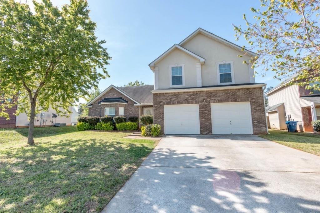 a front view of a house with a yard and garage