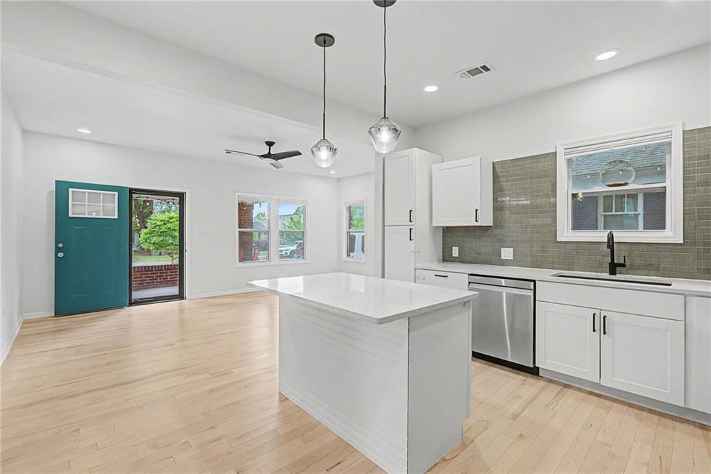 827 Elbert Street Southwest Atlanta, GA 30310 - Photo 7 of 33 a large kitchen with kitchen island a sink stainless steel appliances and a chandelier