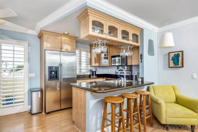 a kitchen with stainless steel appliances granite countertop a sink and a refrigerator