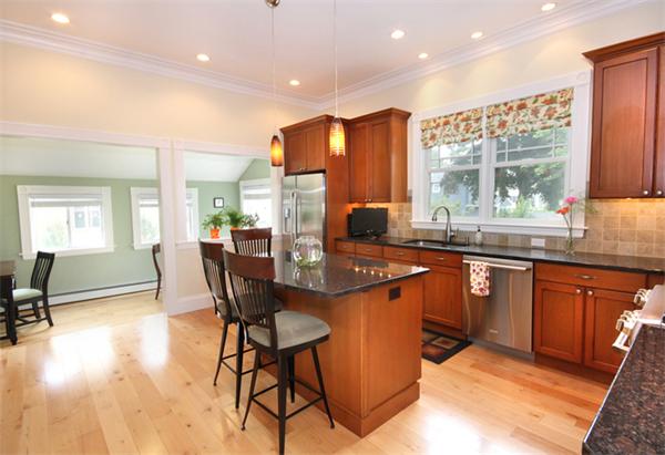 a kitchen with stainless steel appliances granite countertop sink stove and wooden cabinets