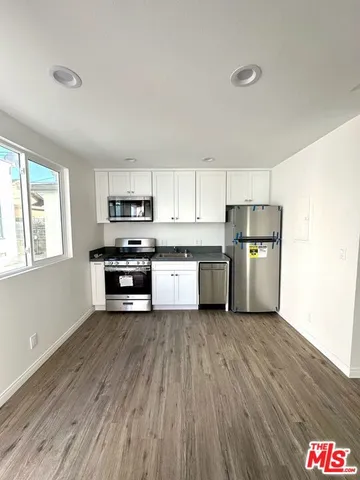 a kitchen with stainless steel appliances a refrigerator and a stove top oven