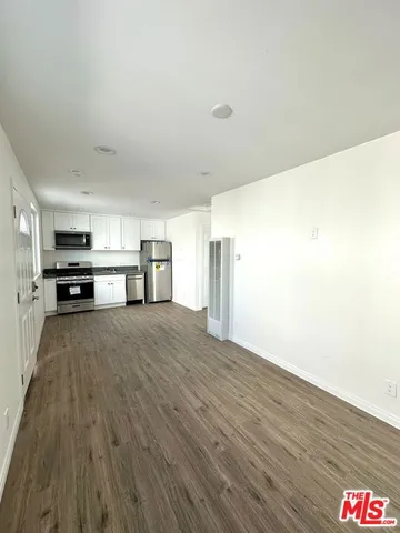 a view of empty room with furniture and wooden floor