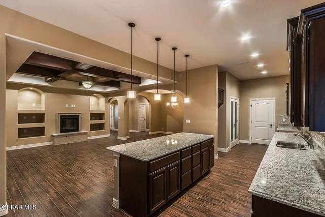 a open kitchen with stainless steel appliances granite countertop a kitchen island a stove and a wooden floors