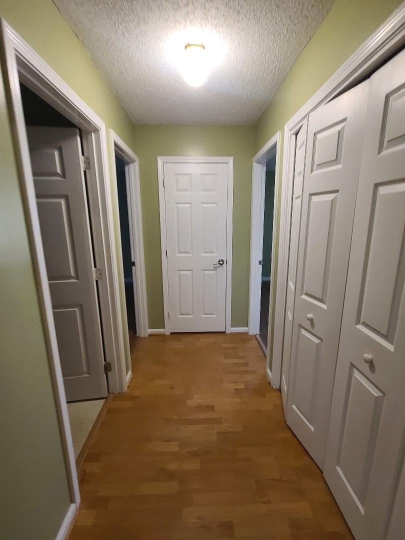 11996 Swooping Willow Road Jacksonville, FL 32223 - Photo 13 of 13 Corridor with a textured ceiling and light wood-type flooring