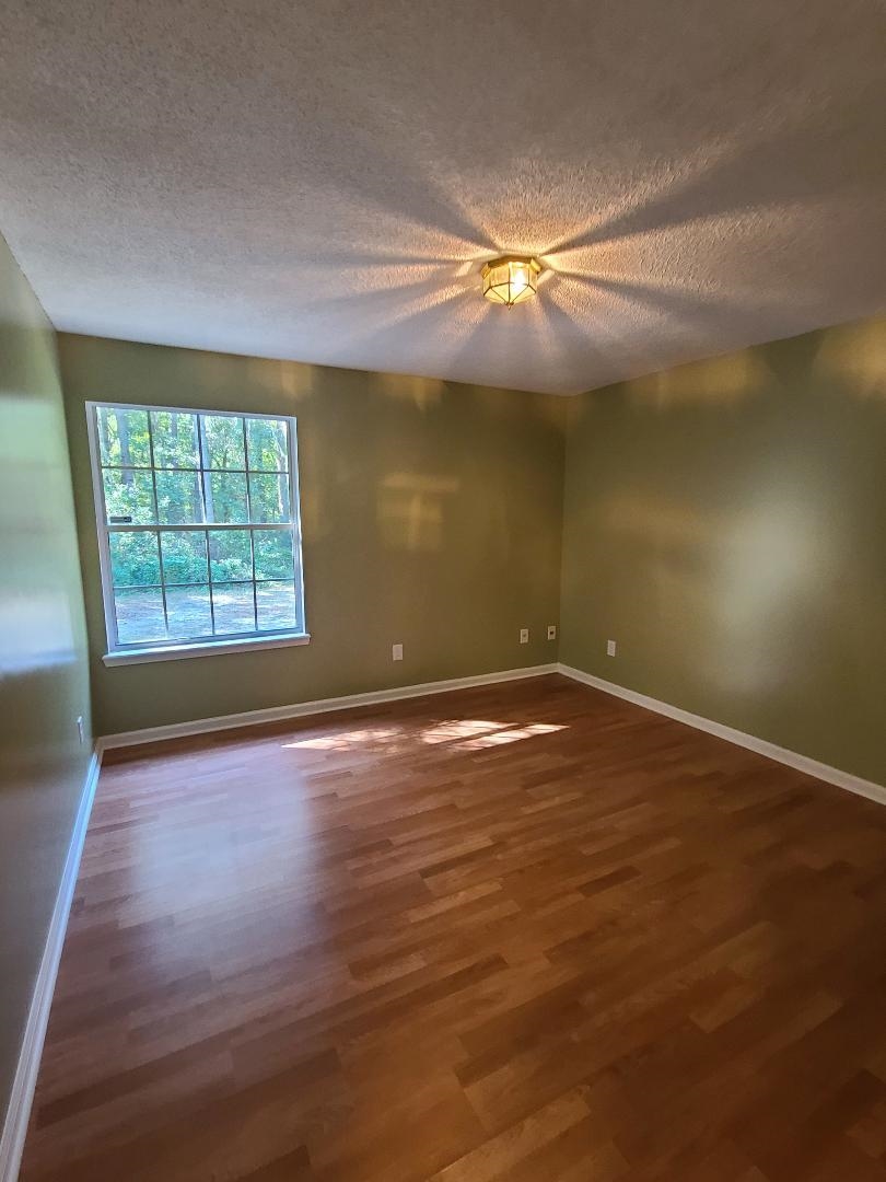 11996 Swooping Willow Road Jacksonville, FL 32223 - Photo 10 of 13 Spare room with a textured ceiling and dark wood-type flooring