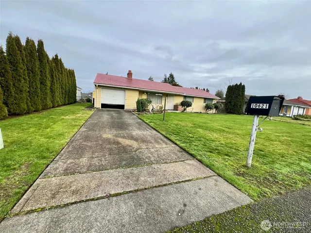 a view of a house with backyard and a garden