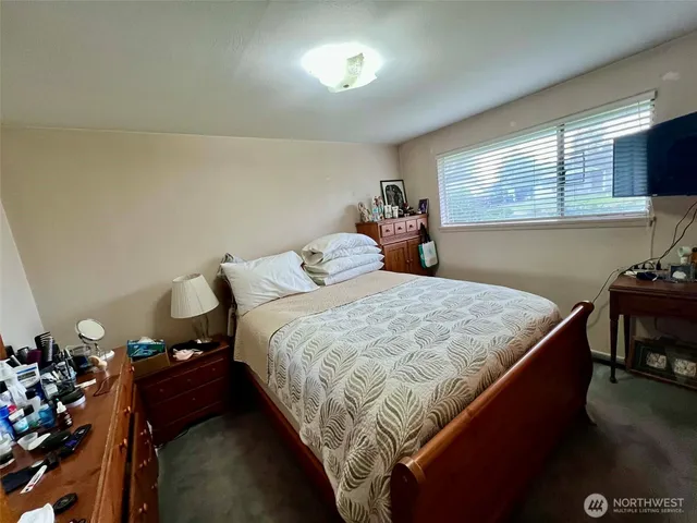 a bedroom with a bed and a tv