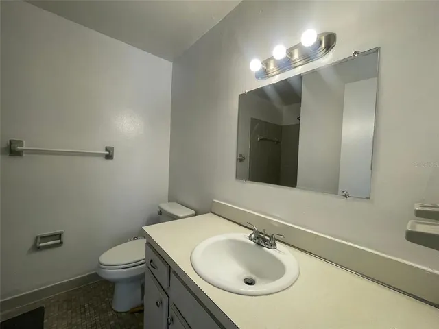 a bathroom with a sink a toilet and mirror