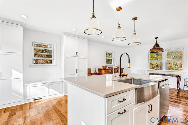 a kitchen with stainless steel appliances a sink a stove a center island and a window