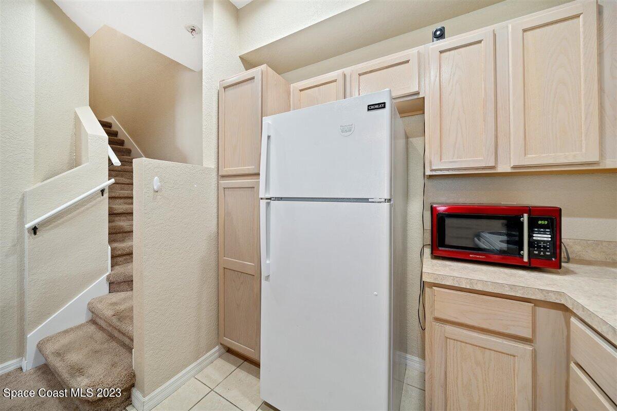 110 Colibri Way, Unit 107 Melbourne, FL 32901 - Photo 12 of 27 a white refrigerator freezer and a stove sitting inside of a kitchen
