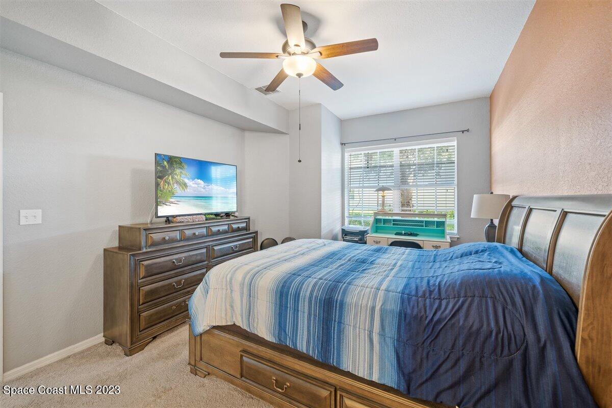 110 Colibri Way, Unit 107 Melbourne, FL 32901 - Photo 14 of 27 a bedroom with a bed and a flat screen tv