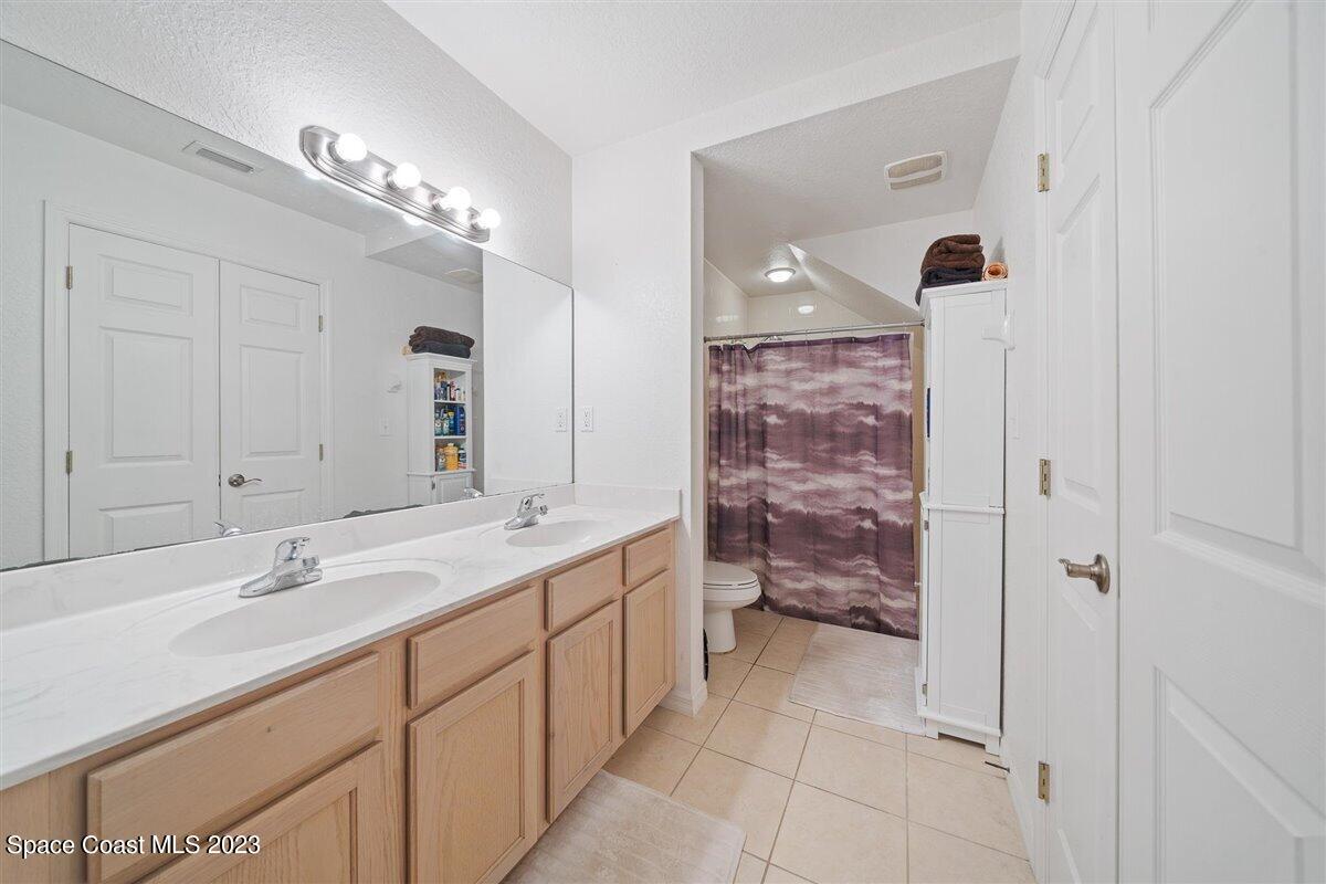 110 Colibri Way, Unit 107 Melbourne, FL 32901 - Photo 15 of 27 a bathroom with a double vanity sink and mirror