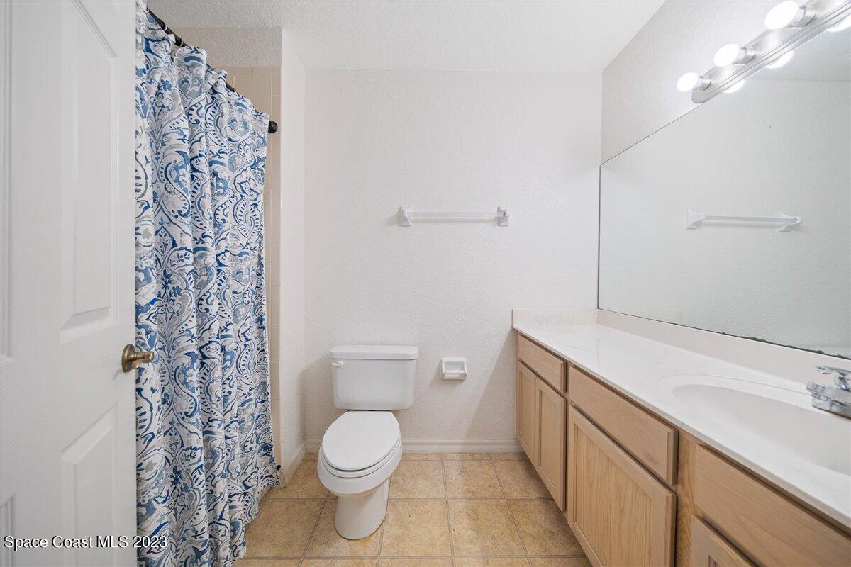 110 Colibri Way, Unit 107 Melbourne, FL 32901 - Photo 19 of 27 a bathroom with a toilet and a shower curtain