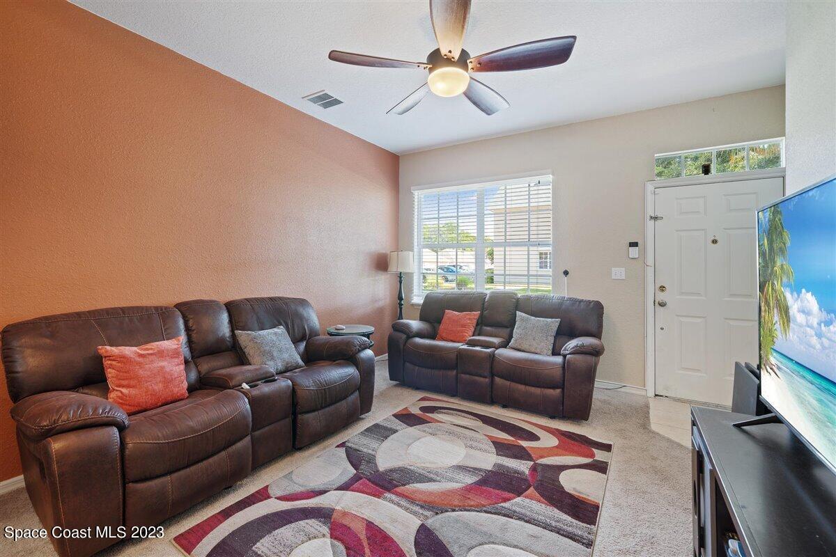 110 Colibri Way, Unit 107 Melbourne, FL 32901 - Photo 7 of 27 a living room with furniture a flat screen tv and a window