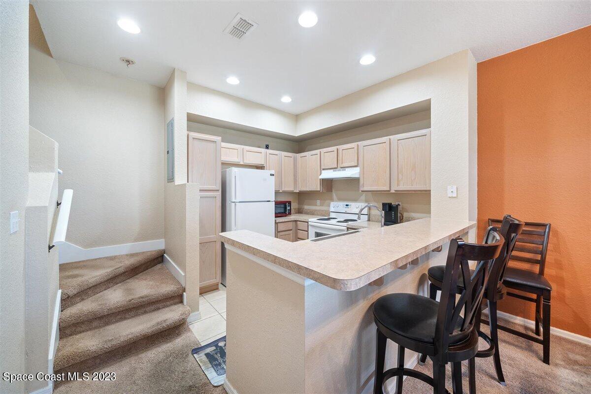110 Colibri Way, Unit 107 Melbourne, FL 32901 - Photo 9 of 27 a kitchen with refrigerator and white cabinets