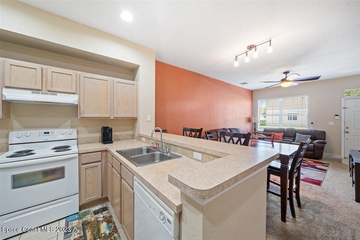 110 Colibri Way, Unit 107 Melbourne, FL 32901 - Photo 10 of 27 a kitchen that has a sink a stove and chairs