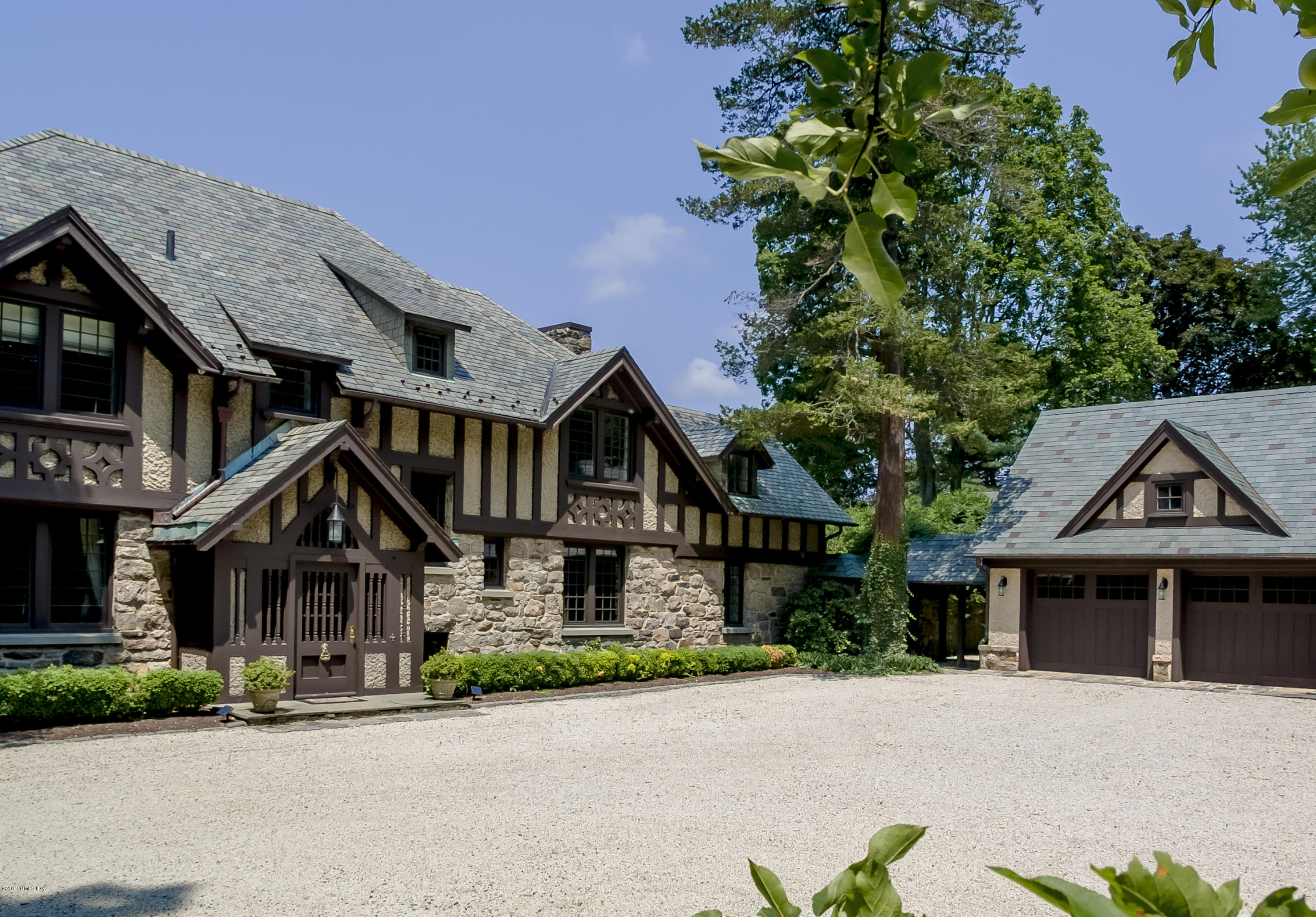 a front view of a house with a yard and a car park